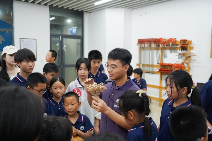 一码通基础实验与工程实践中心老师正在给研学团成员讲解榫卯工艺。 一码通